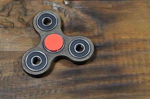 beliebtes Fingerspinner-Gerät. modernes Fidget-Spinnspielzeug auf Lagern. Drehen Sie es in den Händen, lernen Sie coole neue Tricks. Viel Spaß mit diesem neuen rotierenden Gadget foto