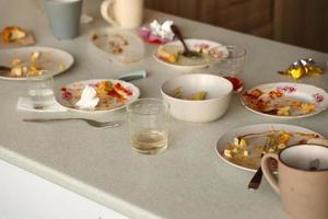 Leere schmutzige Teller mit Löffeln und Gabeln nach dem Essen auf dem Tisch. Bankettabschlusskonzept. ungewaschenes Geschirr foto