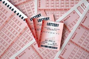 Der rote Lottoschein liegt auf rosafarbenen Glücksspielblättern mit Zahlen zum Markieren, um Lotto zu spielen. lotteriespielkonzept oder spielsucht. Nahansicht foto