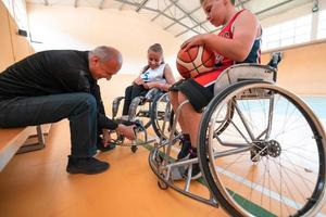 Der Trainer der Basketballmannschaft mit Behinderung bereitet die Spieler auf den Spielbeginn vor. selektiver Fokus foto