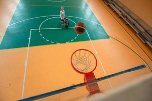 Abschleppfoto eines Kriegsveteranen, der Basketball in einer modernen Sportarena spielt. das Konzept des Sports für Menschen mit Behinderungen foto