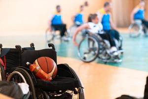 Nahaufnahme von Rollstühlen und behinderten Kriegsveteranen, die auf dem Platz Basketball spielen foto