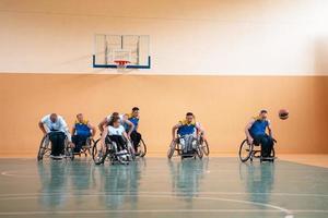 ein Foto von Basketballmannschaften mit Behinderungen mit dem Auswähler in der großen Halle vor Beginn des Basketballspiels