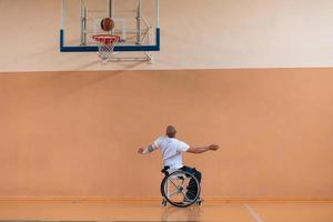 ein Foto eines Kriegsveteranen, der in einer modernen Sportarena Basketball spielt. das Konzept des Sports für Menschen mit Behinderungen