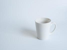 weiße kaffeetasse draufsichtfoto auf einer weißen untertasse das innere des glases sieht leer aus. Warten auf das Nachfüllen von heißem Kaffee zum Trinken, um sich auf weißem Hintergrund erfrischt und wach zu fühlen. foto
