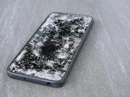 Das Smartphone schlug auf dem Boden auf, es fiel in eine Ritze. foto