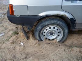 das Rad des Autos steckt im Sand fest. festsitzende Reifen. foto