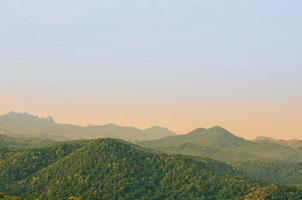 die morgendliche szene mit sonnenlicht, das auf die berglandschaft mit wald im ländlichen gebiet im norden thailands scheint. foto