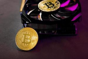 Auf den Fans einer leistungsstarken Grafikkarte werden die Münzen der Bitcoin-Kryptowährung mit roter Hintergrundbeleuchtung angezeigt. foto