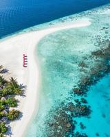 erstaunlicher ruhiger Meeressandhimmel. Freizeittourismus im Sommer. Luftbild mit Stühlen und Sonnenschirmen am paradiesischen Inselstrand, am Meer. Resorturlaub, exotische Natur. schöne Tropen foto