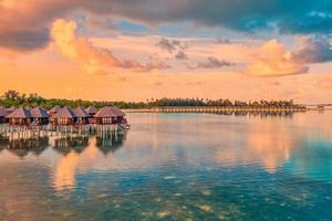 Wunderschöner Sonnenuntergang im Paradies auf den Malediven. tropische Luftlandschaft, Meereslandschaft, Wasservillen, erstaunlicher Meereshimmel, Lagunenstrand, tropische Natur. exotisches tourismusziel, sommerlufturlaub, drohnenansicht. foto