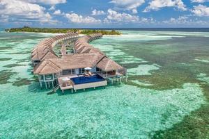 Schönes Malediven-Paradies. tropische luftreiselandschaft, seelandschaft mit holzbrücke, wasservillen, erstaunlicher meeressandhimmelstrand, tropische inselnatur. exotisches tourismusziel sommerferien foto