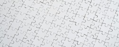 Textur eines weißen Puzzles im zusammengebauten Zustand hautnah. Ansicht von oben. Viele Bestandteile eines großen Gesamtmosaiks sind vereint foto