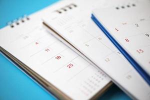 Kalenderseite hautnah auf blauem Hintergrund Geschäftsplanung Termin Meeting Konzept foto