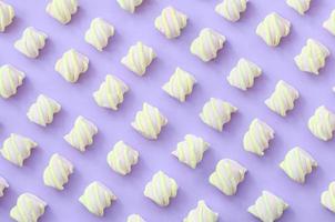 bunter Marshmallow auf violettem Papierhintergrund. pastellfarbenes, kreatives Strukturmuster. minimal foto