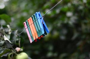 Wäscheklammern an einem Seil, das außerhalb des Hauses und des Apfelbaums hängt foto