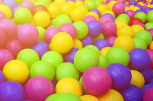 Viele bunte Plastikbälle in einem Bällebad für Kinder auf einem Spielplatz. Muster schließen foto