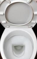 ein Foto einer Toilettenschüssel aus weißer Keramik in der Umkleidekabine oder im Badezimmer. Sanitärkeramik zur Bedarfskorrektur