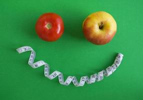 eine Tomate, ein Apfel und ein Zentimeterband foto