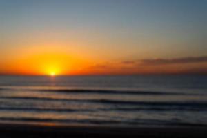 Unscharfes Foto eines schönen und romantischen Sonnenaufgangs an einer Küste