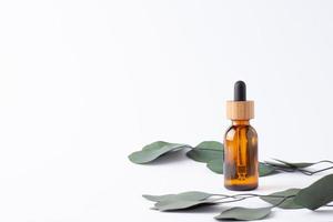 Kosmetikflasche mit Eukalyptus auf weißem Hintergrund. nahaufnahme, kopierraum foto