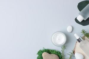 kosmetische hautpflegeprodukte mit eukalyptus und holz auf grauem hintergrund. flach liegend, kopierraum. foto