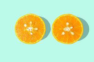 zwei geschnittene orangen auf hellblauem pastellhintergrund.vitamin c concepe. foto