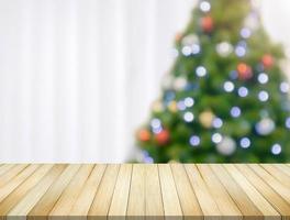 leere tischplatte mit verschwommenem weihnachtsbaum mit bokeh hellem hintergrund foto