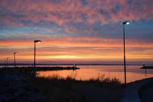 Sonnenuntergang in Schweden am Hafen des Vätternsees. Leuchtturm im Hintergrund in der Abenddämmerung. Landschaftsaufnahme in Skandi foto