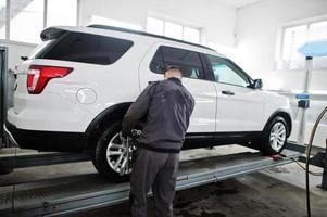 Automechaniker setzt amerikanisches SUV-Auto zur Diagnose und Konfiguration Sturzprüfung in der Werkstatt der Tankstelle.. foto