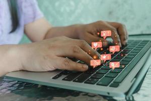 Frau, die Computer-Laptop-Symbole für soziale Netzwerke verwendet und E-Mail für digitales Marketing im Internet arbeitet. foto