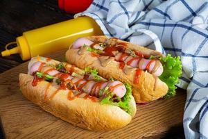 Köstlicher Hot Dog mit Ketchup und Senf auf Holzhintergrund. Straßenessen foto