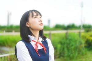 porträt der jungen frau mit kurzen haaren tragen japanische studentenuniform foto