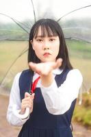 Porträt von Cosplay junge Frau kurze Haare tragen japanische High School Uniform mit Regenschirm foto