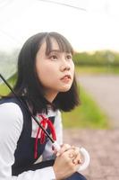 Porträt von Cosplay junge Frau kurze Haare tragen japanische High School Uniform mit Regenschirm foto