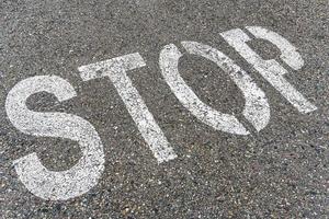 Stoppschild auf der Straße mit strukturiertem Asphalt. foto