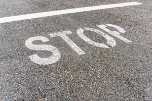 Stoppschild auf der Straße mit strukturiertem Asphalt. foto