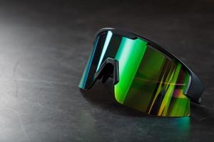 grüne Sportbrille mit Spiegelglas auf dunklem Hintergrund foto