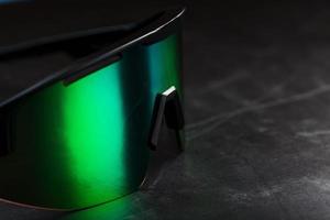 grüne Sportbrille mit Spiegelglas auf dunklem Hintergrund foto