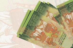 1000 Sri-Lanka-Rupien-Scheine liegen im Stapel auf dem Hintergrund einer großen halbtransparenten Banknote. abstrakte Darstellung der Landeswährung foto