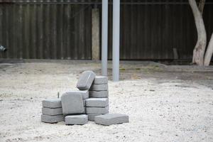 kleiner Haufen grauer Gehwegplatten, die draußen im Stapel liegen. Material für Pflastersteine von Mosaik in Arbeit. Pflastersteininstallation foto