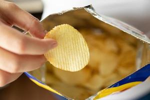 hand halten kartoffelchips mit snackbeutel foto