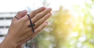 asiatische junge christen zeigen und geben anderen menschen eine kette mit einem kreuz, weicher und selektiver fokus, konzept, um anderen menschen auf der ganzen welt stolz darauf zu zeigen, christen zu sein. foto