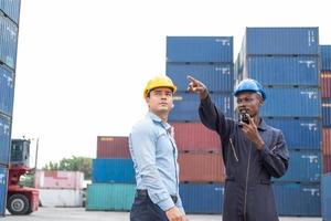 selektiver Fokus auf afrikanische schwarze Arbeiter, während sie mit dem Vorgesetzten sprechen und diskutieren und den Zustand aller Containertransporte, Personen und Arbeiter bei der Frachtlieferung, dem Import und Export inspizieren. foto