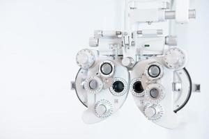 selektiver fokus auf optometrierahmenausrüstung. mit unscharfem weißem Hintergrund für Kopienraum. Optometristen-Tool zur Untersuchung des visuellen Augensystems des Patienten mit einer professionellen Maschine vor der Herstellung einer Brille. foto