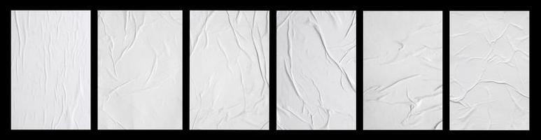 weißes zerknittertes und zerknittertes geklebtes papierplakatset lokalisiert auf schwarzem hintergrund foto