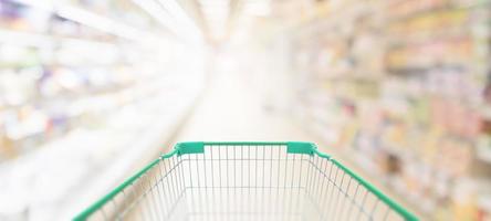 leerer grüner einkaufswagen im supermarktgang foto