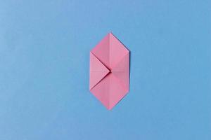 Schritt 3. Origami-Schweinskopf. Nehmen Sie zwei gegenüberliegende Ecken und falten Sie sie zur Mitte des Blattes. foto