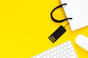 kabellose Tastatur und Maus mit Einkaufstasche für Online-Shopping mit gelbem Hintergrund. cybermontag und konzept.