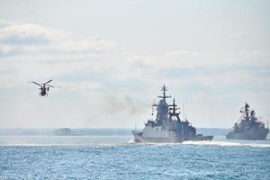 schlachtschiffe kriegsschiffe korvette während marineübungen und hubschrauber manövrieren über meer, kriegsschiffe foto